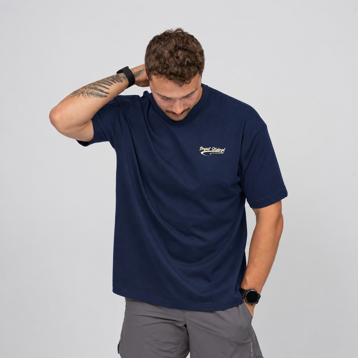 Men’s navy oversized HYBRYD gym T-shirt with small Project Hybryd chest graphic and relaxed fit. Worn with grey wod shorts. From gymwear brand Hybryd.