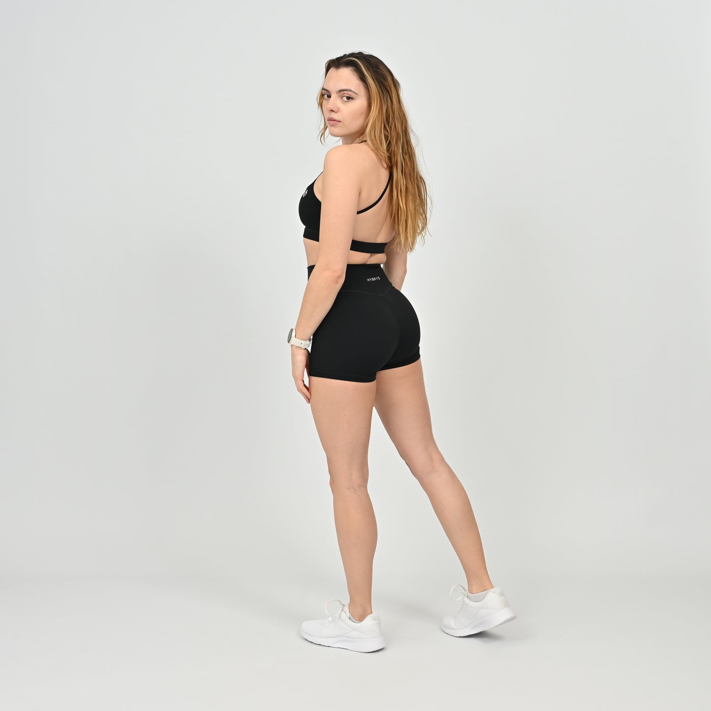 Woman wearing a black sports bra and booty shorts set