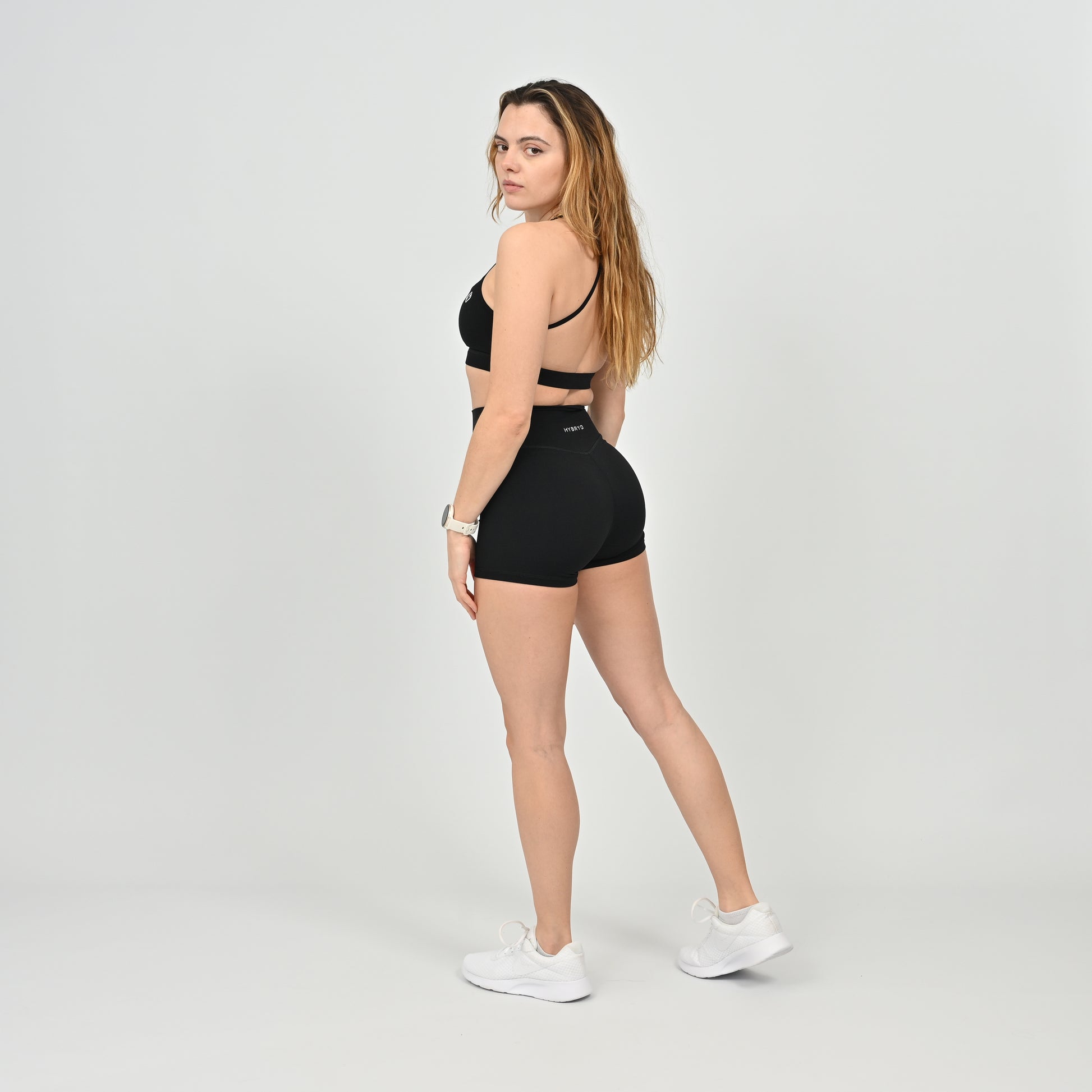 Woman wearing a black sports bra and booty shorts set