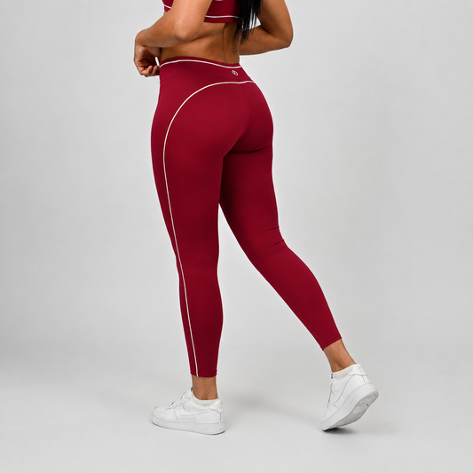 Maroon yoga leggings with Hybryd logo and  white piping worn by a crossfit athlete on a gray background