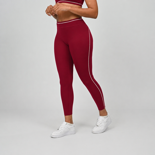 Scarlet pilates leggings with white stripes worn by a Hybryd  athlete on a gray background