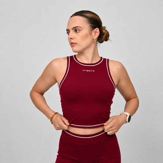 Hybryd athlete wearing a maroon crossfit outfit with piping and a 'HYBRYD' branding on a gray background