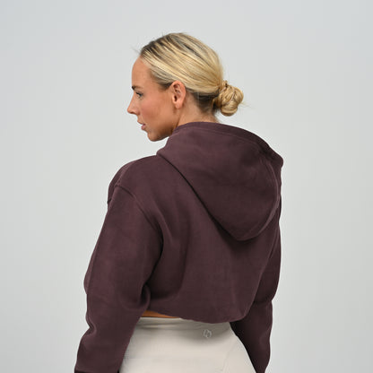 Back profile view of model wearing the aubergine Hybryd Barstow cropped sweatshirt hoodie component
