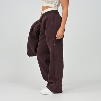 Side profile view of model wearing the aubergine Hybryd Barstow wide leg joggers matching lounge set component