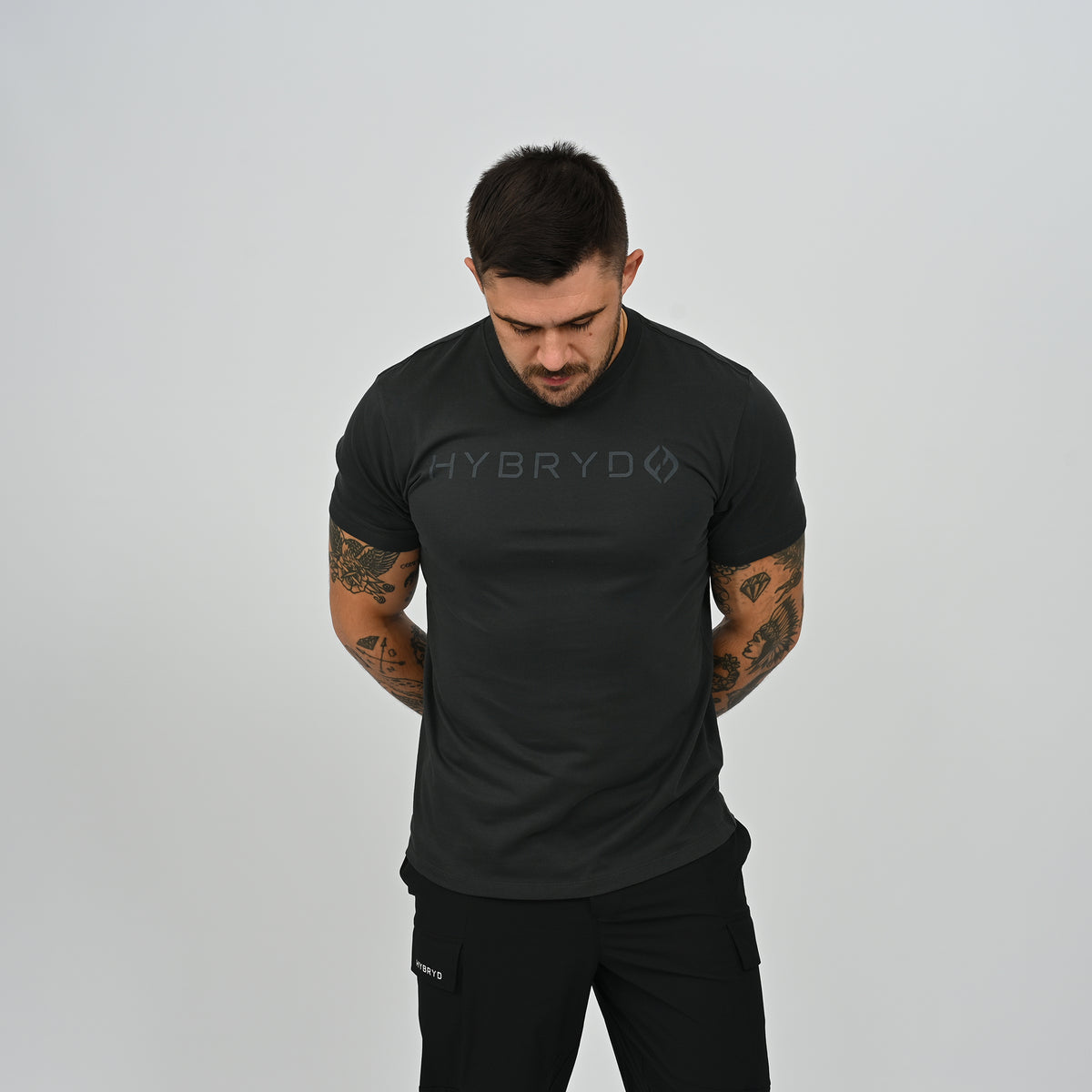 Front angle view of male athlete wearing black Hybryd Delta Core CrossFit gym t-shirt   