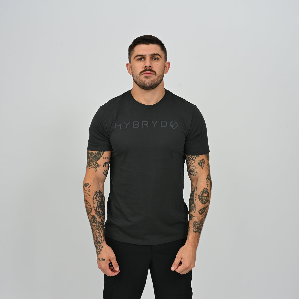 Front view of male athlete wearing black Hybryd Delta Core athletic gym t-shirt   
