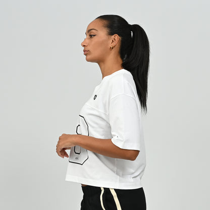 Side profile view of a model wearing the white HAFT collegiate style American football jersey t-shirt by Hybryd.