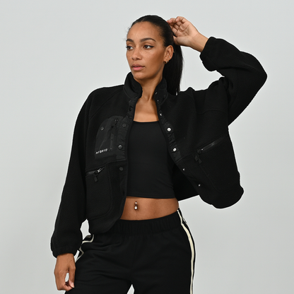 Full length front view of female model wearing women's black Hybryd Huntsville button-up teddy fleece jacket