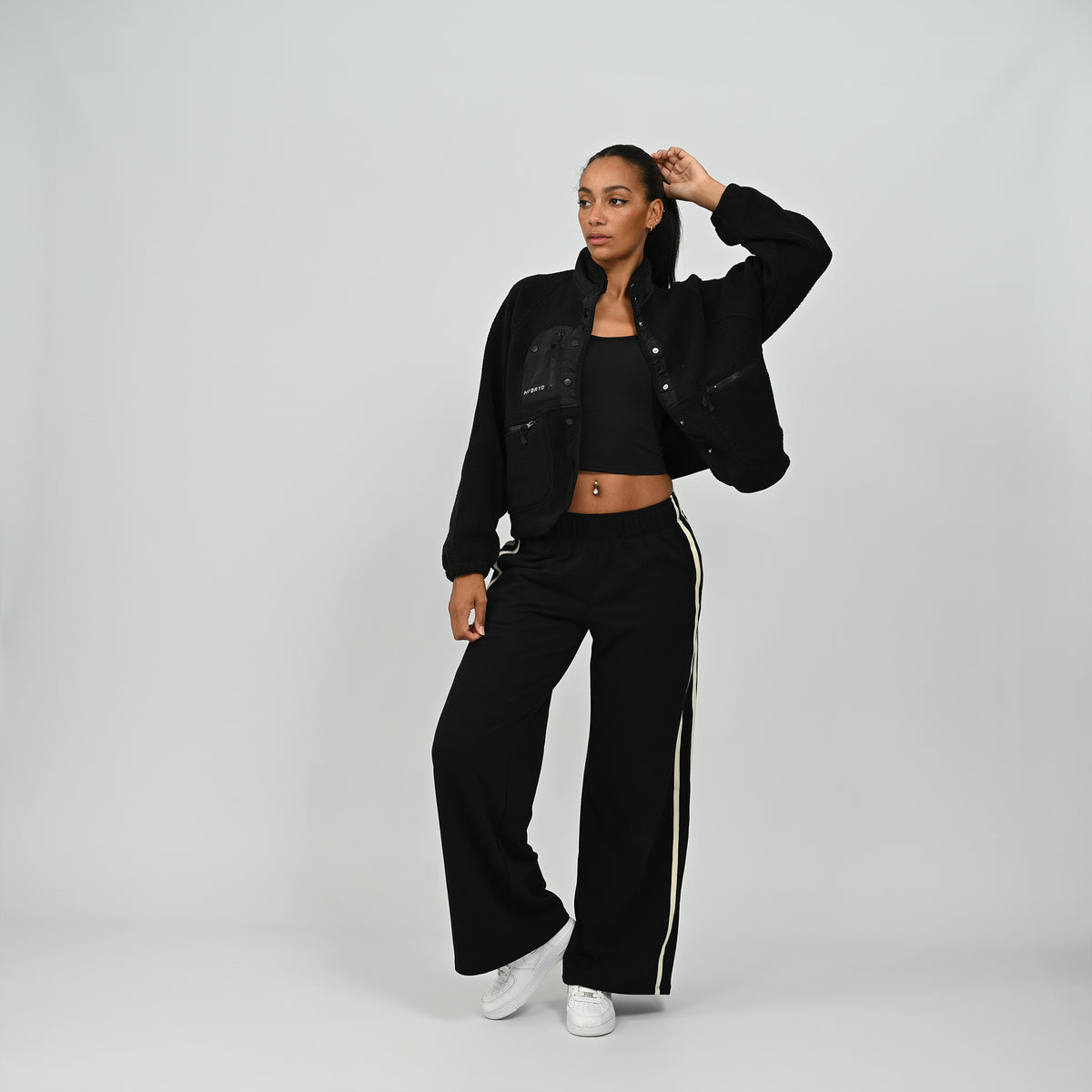 Full body view of model wearing women's black Hybryd Huntsville teddy fleece jacket with matching trousers