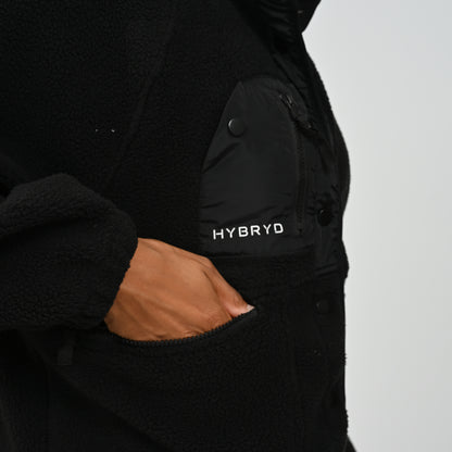 Close-up view of sleeve elasticated cuff and zipped pocket on women's black Hybryd Huntsville fleece