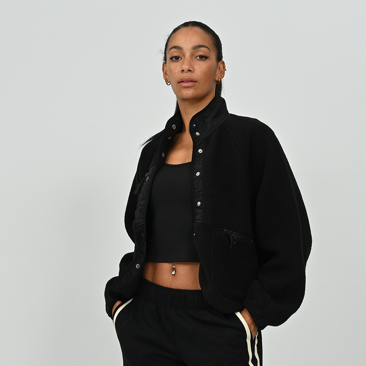 Three-quarter angle view of female model wearing women's black Hybryd Huntsville fleece jacket   