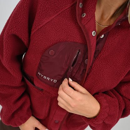 Detail shot of button-up front closure and chest pocket on women's wine Hybryd Huntsville teddy fleece jacket