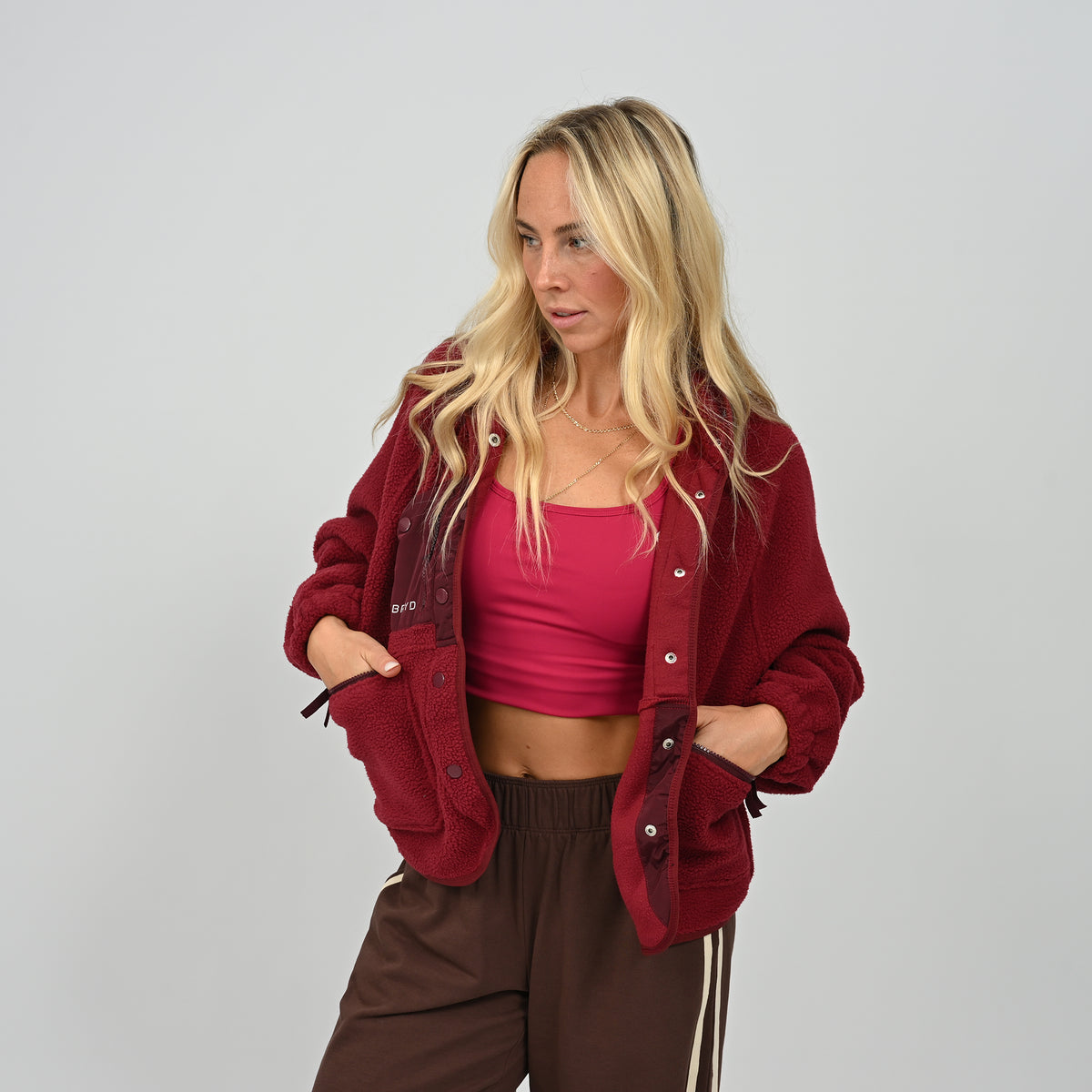 Front view of model posing in unbuttoned women's wine burgundy Hybryd Huntsville cozy fleece jacket