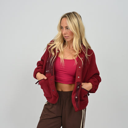 Front view of model posing in unbuttoned women's wine burgundy Hybryd Huntsville cozy fleece jacket