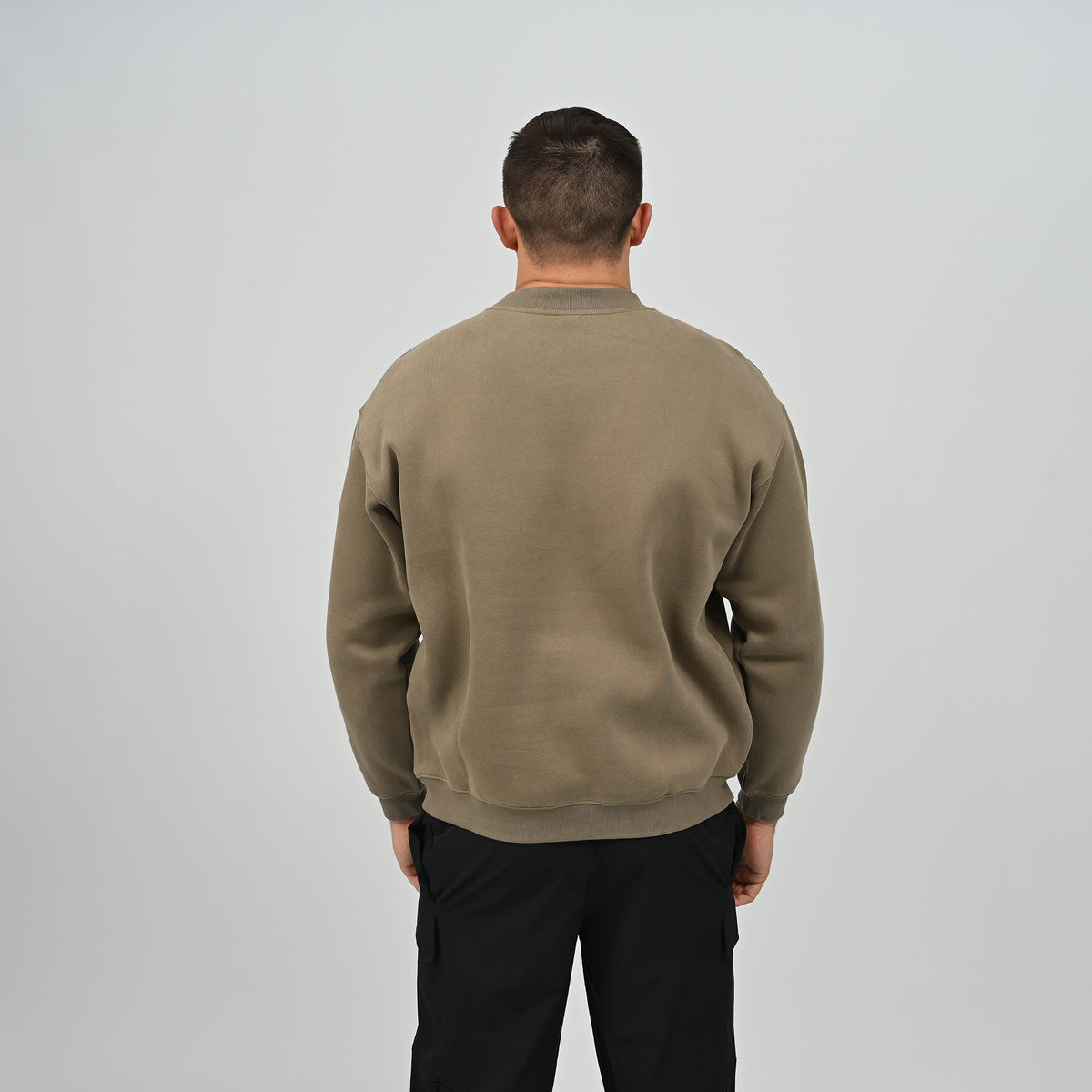 Back view of model wearing the khaki Hybryd Jasper crew neck sweatshirt with drop shoulder seams.
