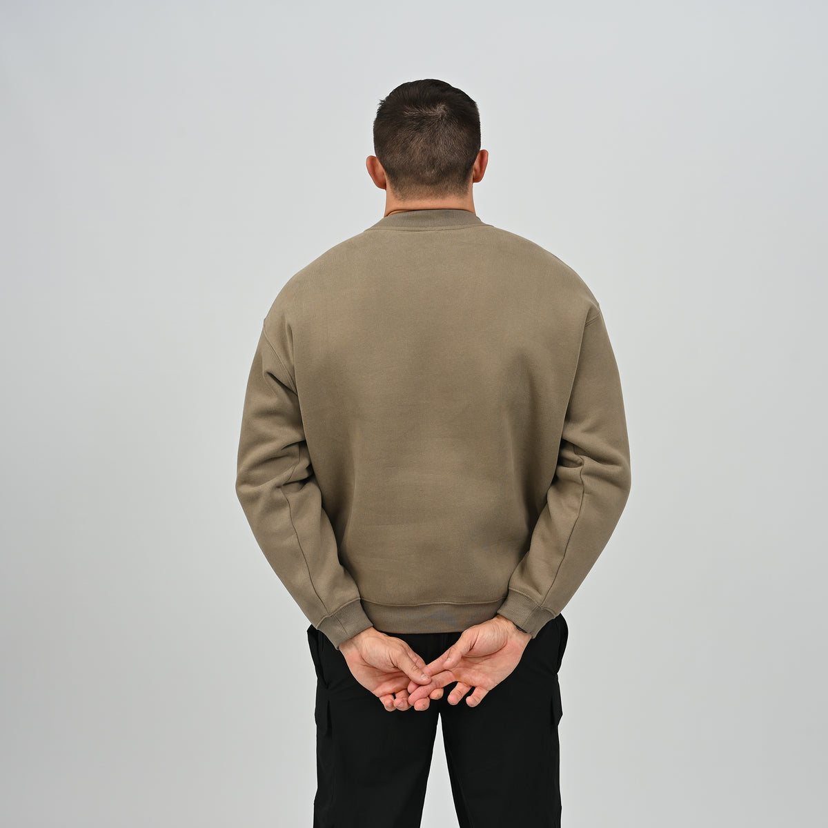 Back view of model wearing the khaki Jasper relaxed fit fleece crew neck sweatshirt.