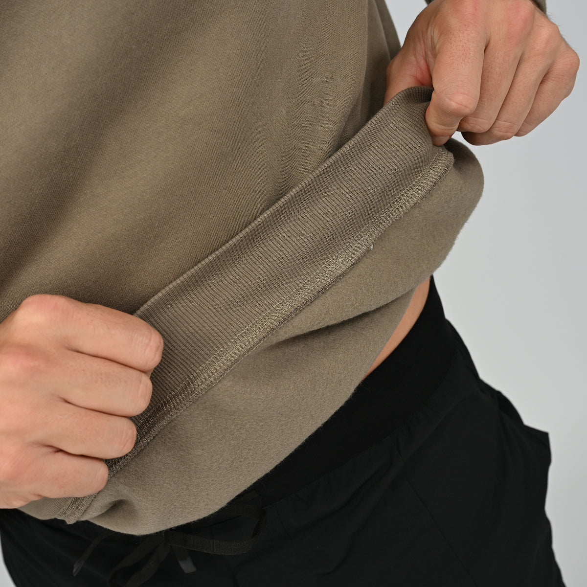 Close-up detail of the ribbed cuff and khaki fabric texture on the Jasper fleece-lined crew neck.