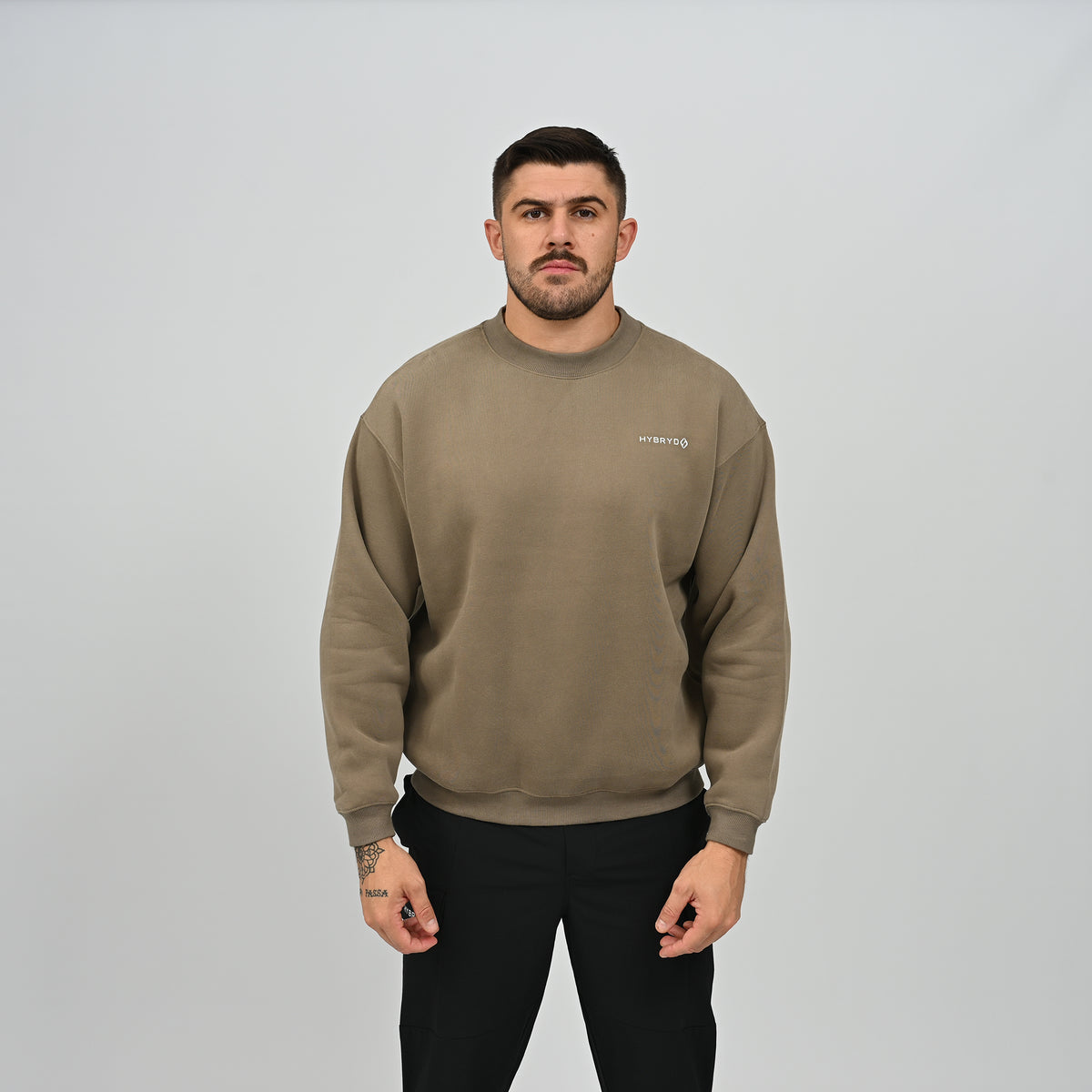 Full front standing view of model in the khaki Hybryd Jasper fleece crew neck sweatshirt.