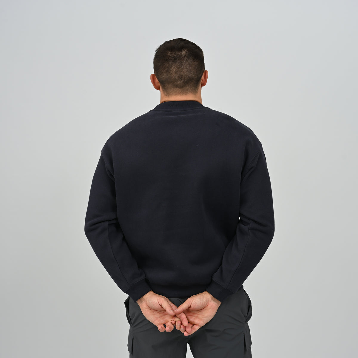 Back view of model wearing the Hybryd Jasper crew neck sweatshirt in navy blue.