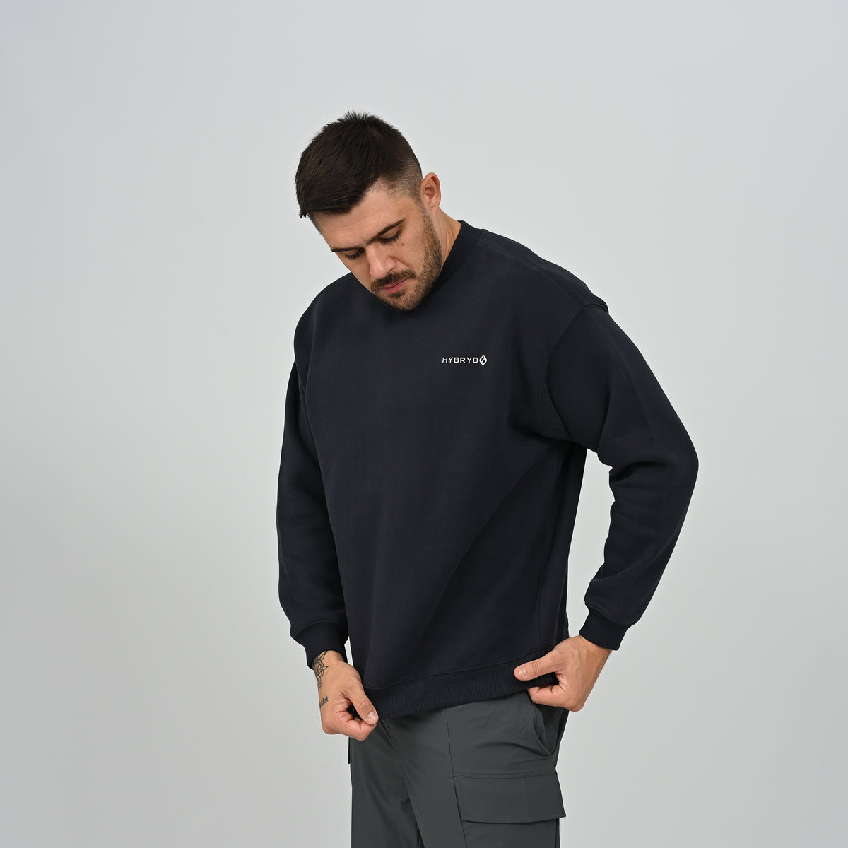 Three-quarter pose of model wearing the navy Hybryd Jasper crew neck sweatshirt.