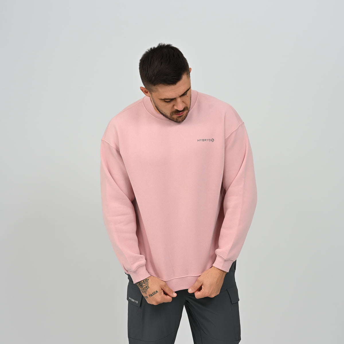 Front view of model in the pink Jasper crew neck sweatshirt standing casually.