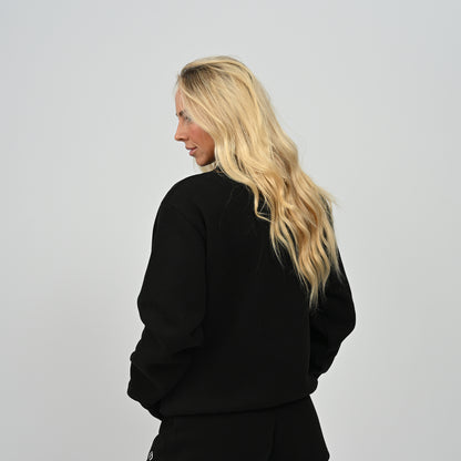 Back view of model wearing the black Hybryd Scottsdale crewneck sweatshirt from the matching lounge set