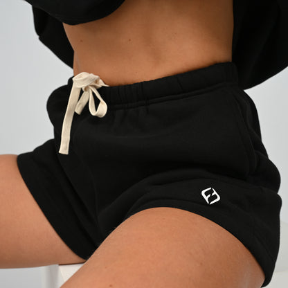 Close-up front view of model wearing the black Hybryd Scottsdale matching set sweat shorts with drawstring waistband
