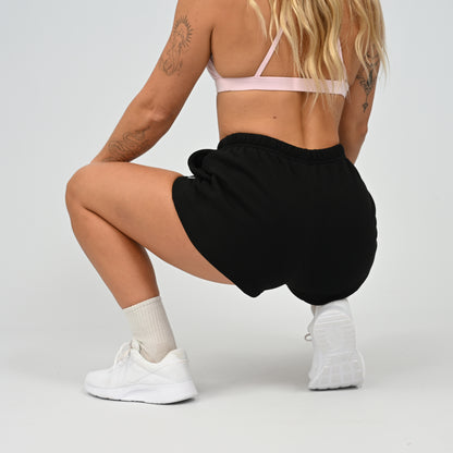 Model sitting wearing the black Hybryd Scottsdale matching lounge sweat shorts   