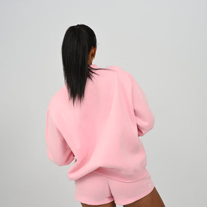 Rear side view of model wearing the pink Hybryd Scottsdale crewneck sweatshirt and matching shorts set
