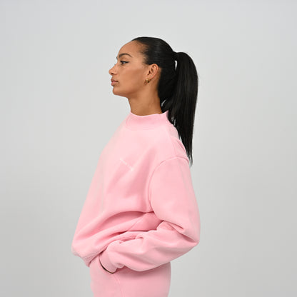 Side view of model posing in the pink Hybryd Scottsdale matching set crewneck sweatshirt and sweat shorts
