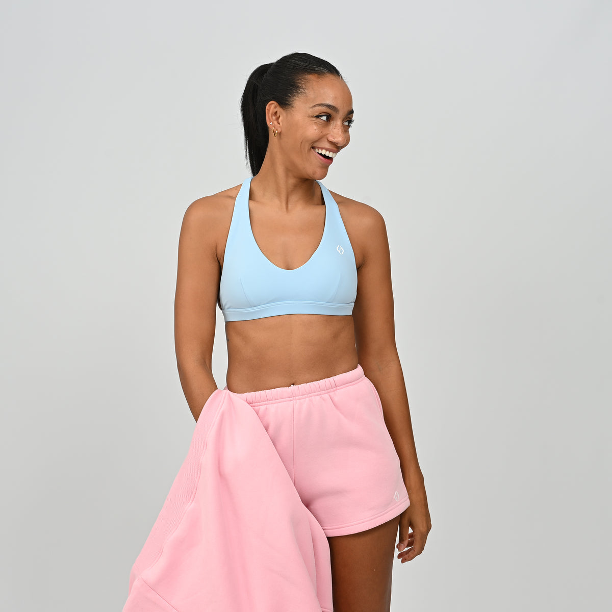 Model wearing pink Hybryd Scottsdale matching sweat shorts paired with a crop top
