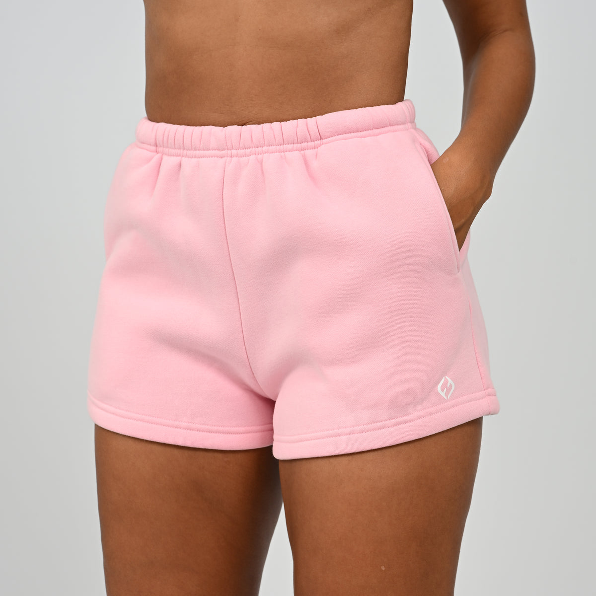 Front mid-section view of model wearing the pink Hybryd Scottsdale lounge sweat shorts matching set component