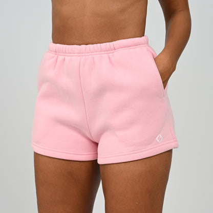 Front mid-section view of model wearing the pink Hybryd Scottsdale lounge sweat shorts matching set component