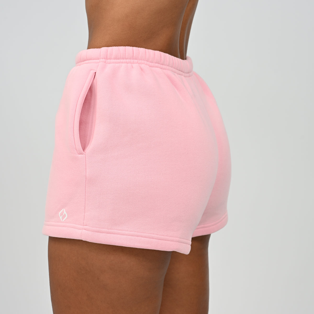 Side close-up view of model wearing the pink Hybryd Scottsdale matching set sweat shorts with pocket