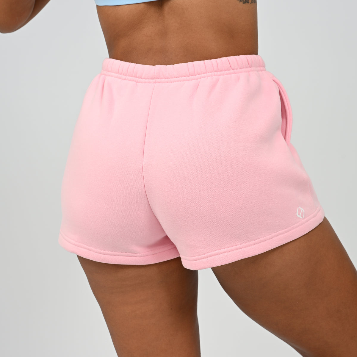 Side view of model wearing the pink Hybryd Scottsdale matching lounge sweat shorts   
