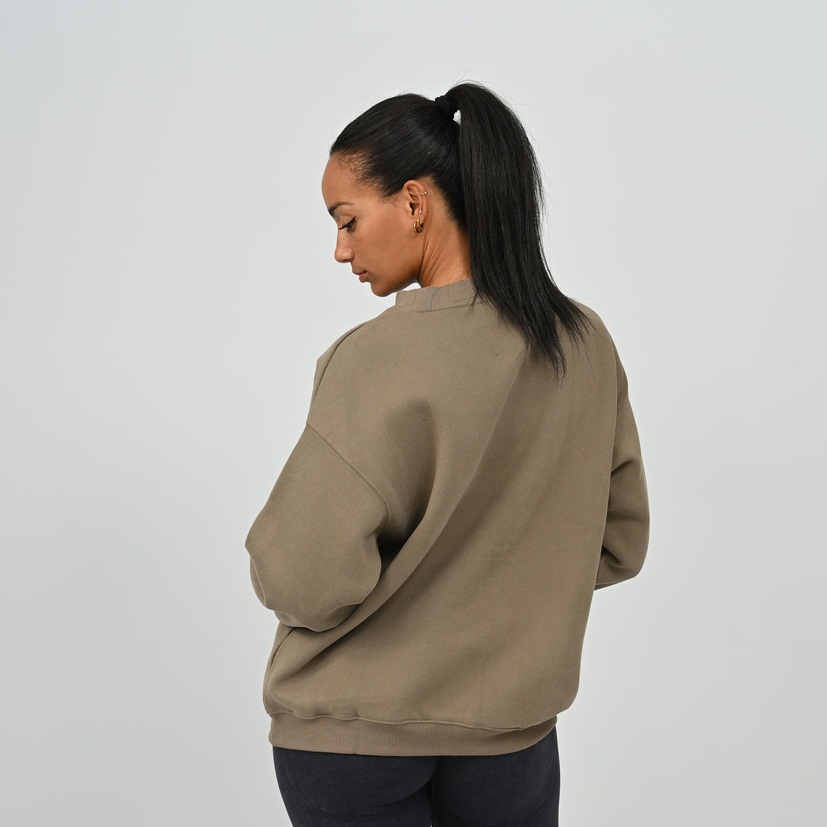 Rear angle view of female model wearing the Women's Hybryd Jasper crew neck sweatshirt in khaki green.
