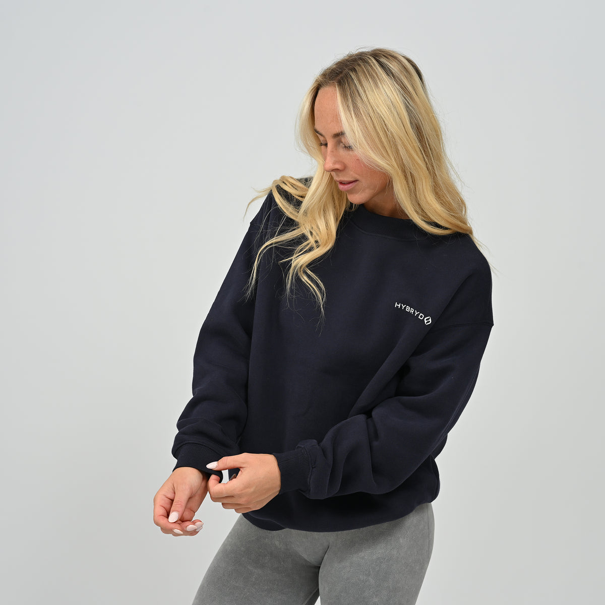 Side angled shot of female model wearing the navy Women's Hybryd Jasper fleece-lined crew neck sweatshirt