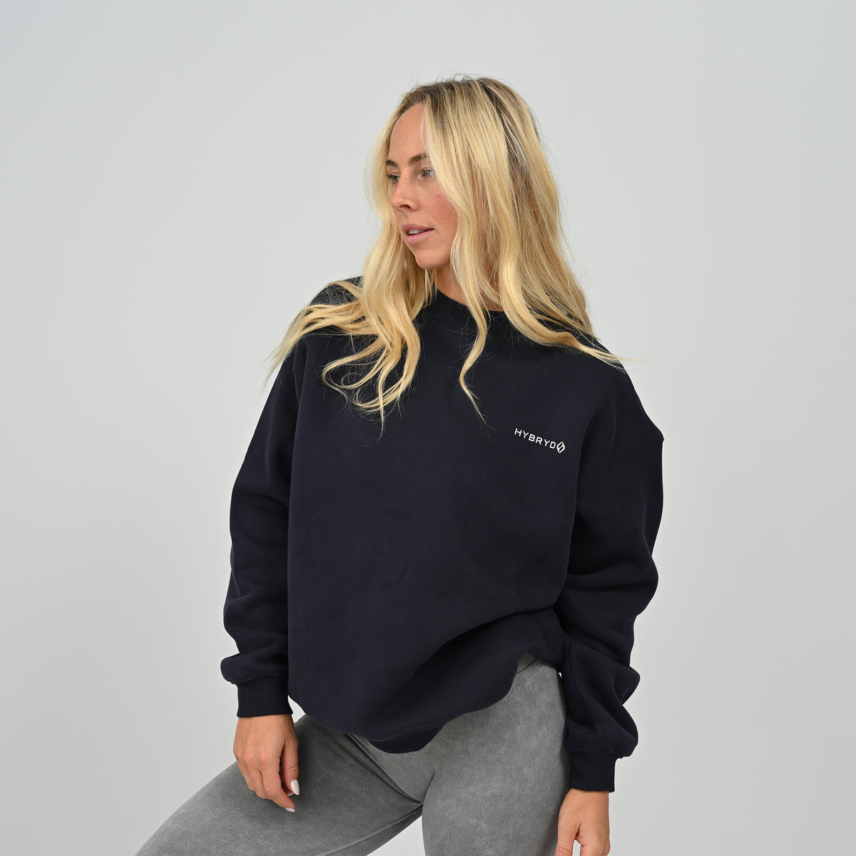 Three-quarter front pose of female model wearing the navy Hybryd Jasper crew neck sweater.