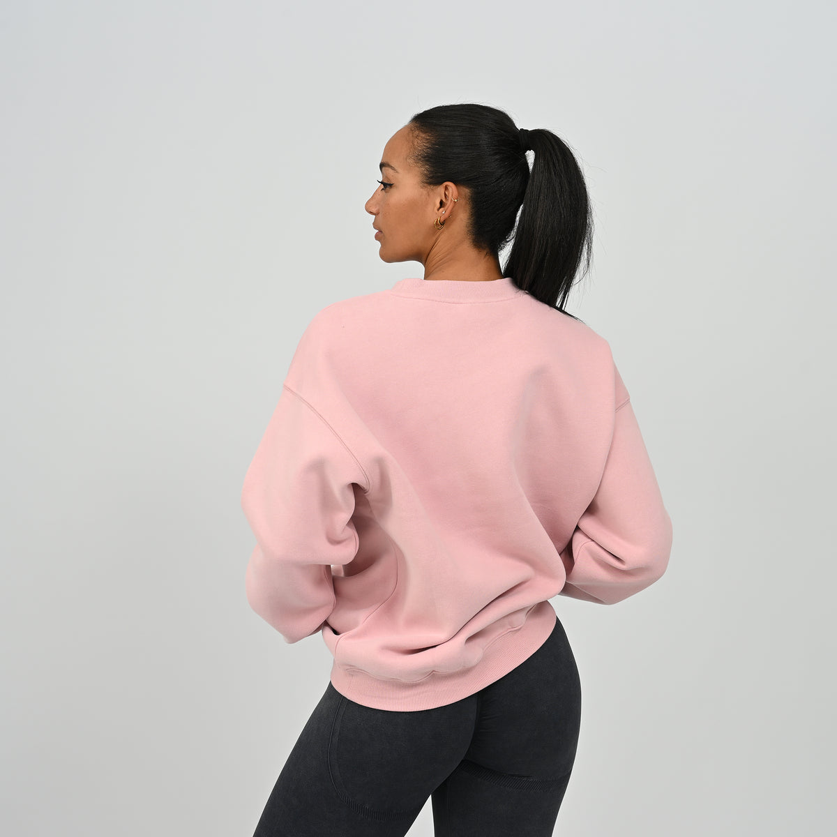 Back three-quarter angle of female model wearing the Women's Jasper crew neck sweater in pink.