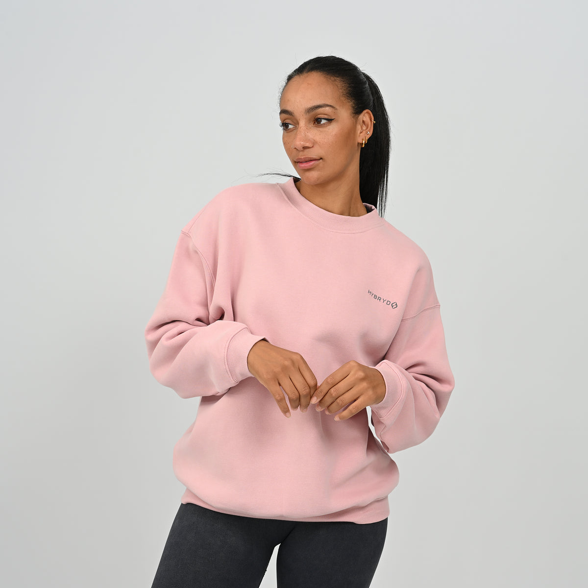 Front view of female model wearing the Hybryd Women's Jasper relaxed fit crew neck sweatshirt in pink.