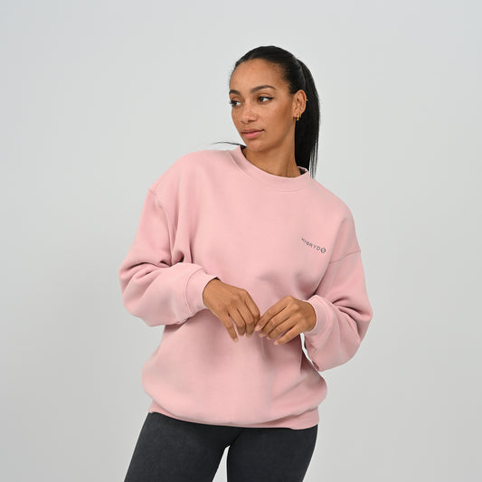 Front view of female model wearing the Hybryd Women's Jasper relaxed fit crew neck sweatshirt in pink.
