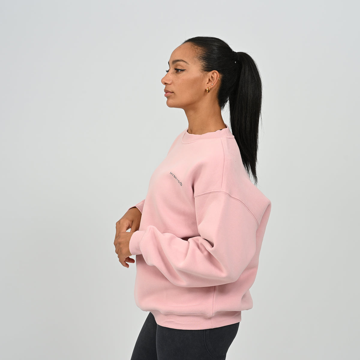 Side profile of female model wearing the pink Women's Jasper relaxed fit fleece crew neck jumper.