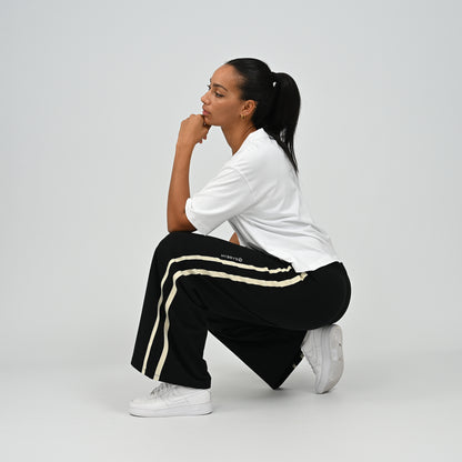 Seated view of model in black Hybryd Milford wide leg lounge joggers   