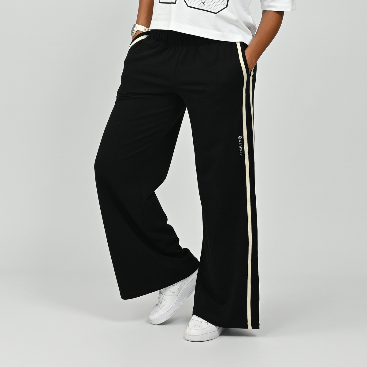 Front view of model wearing black Hybryd Milford wide leg joggers with side stripe   