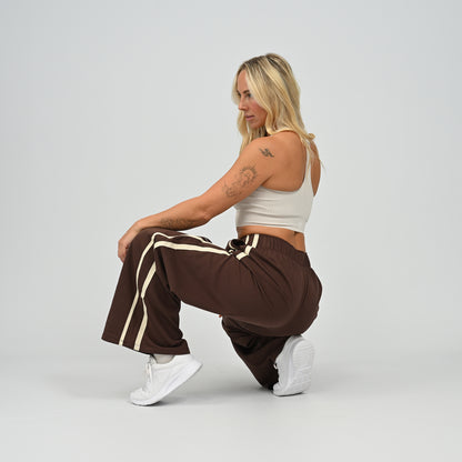 Model crouching pose wearing brown Hybryd Milford wide leg joggers   