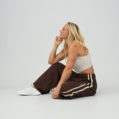 Model sitting on floor in brown Hybryd Milford wide leg joggers   