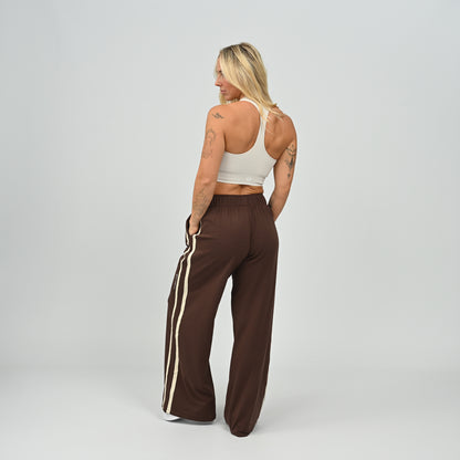 Three-quarter view of model standing in brown Hybryd Milford wide leg joggers   