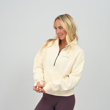 Front posing view of model wearing the cream Hybryd Monterey high collar half zip sweatshirt   