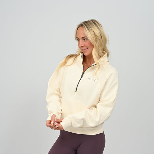 Front posing view of model wearing the cream Hybryd Monterey high collar half zip sweatshirt   