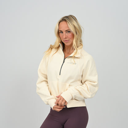 Front view of model wearing the cream Hybryd Monterey half zip sweatshirt with kangaroo pocket
